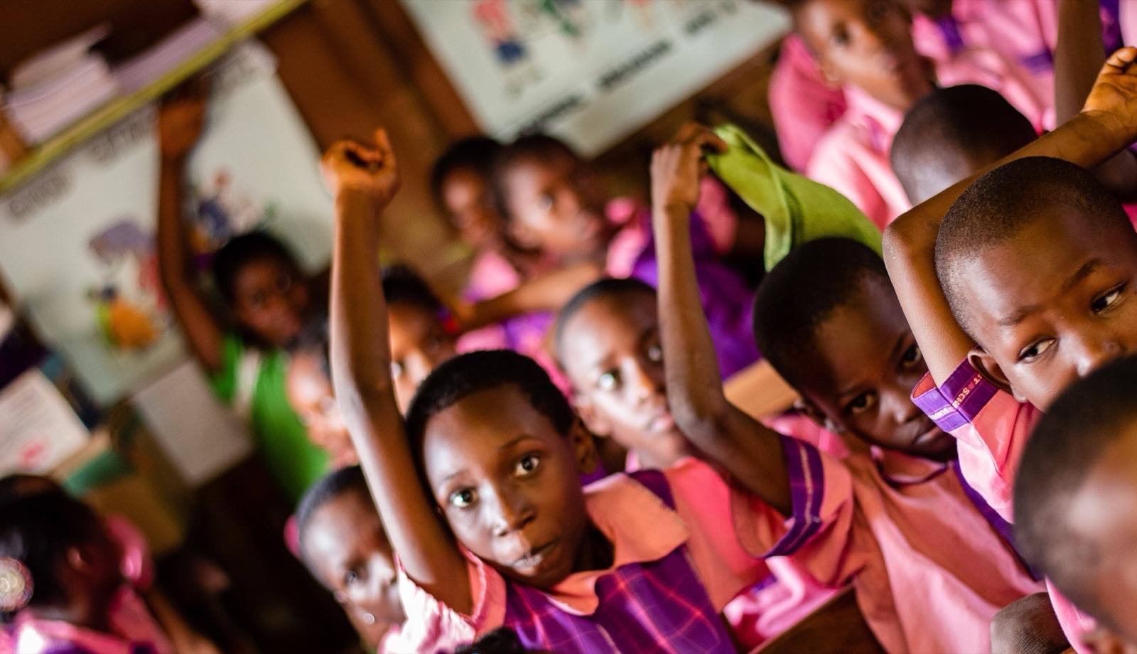 Pupils with their hands up to answer a question