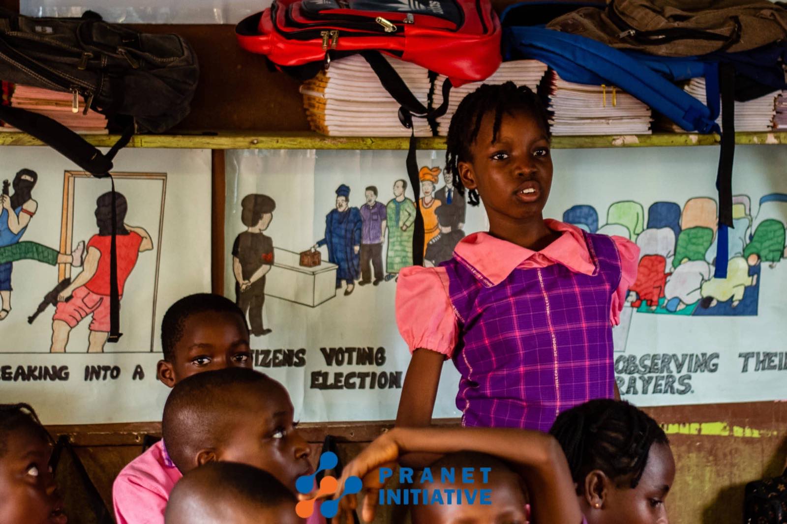 A pupil presenting beside classroom artwork
