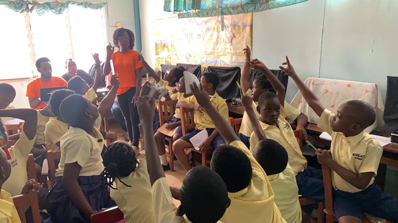 A volunteer teaching a hall full of pupils